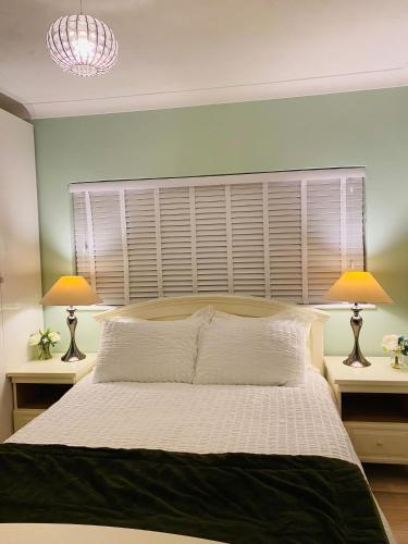 a bedroom with a large bed with two lamps at Relax in this Charming East Cowes House with Garden and BBQ in East Cowes