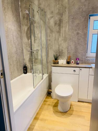a bathroom with a white toilet and a shower at Relax in this Charming East Cowes House with Garden and BBQ in East Cowes