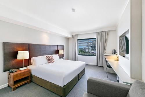 a hotel room with a bed and a couch at Darwin Harbourside Escape - Two Adjacent King Suites in Darwin