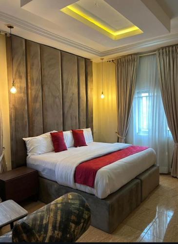 a bedroom with a large bed with red pillows at Maas Nightingale Apartments in Port Harcourt