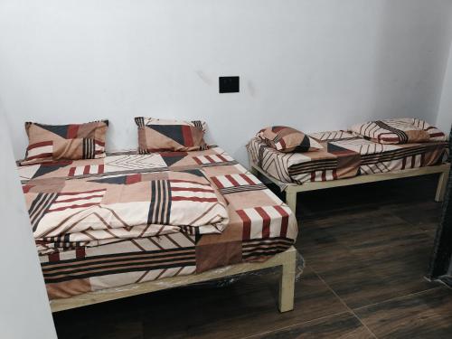 twee bedden naast elkaar in een kamer bij SHiVAY HOMESTAY in Garudeshwar