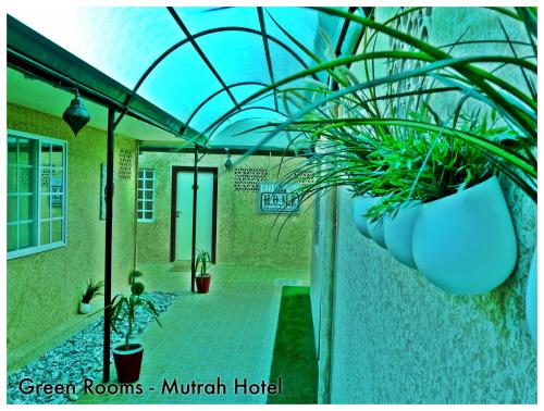 a building with a green rooms mutant hotel with plants at Mutrah Hotel in Muscat