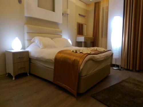 a bedroom with a bed and a night stand with a lamp at Arya Otel in Marmaris