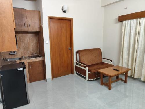 a room with a chair and a table and a door at Best Eastern Apartment in Dhaka