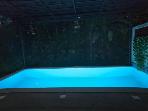 a swimming pool in a backyard at night at Acrewood Farmhouse - Pool Villa in Vāzhākulam