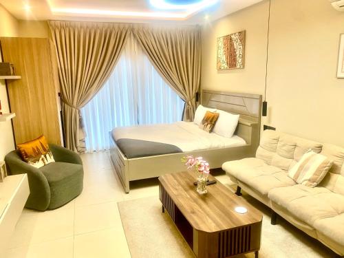 une chambre avec un lit, un canapé et une table dans l'établissement Belrose Place Studio Apartment, à Accra