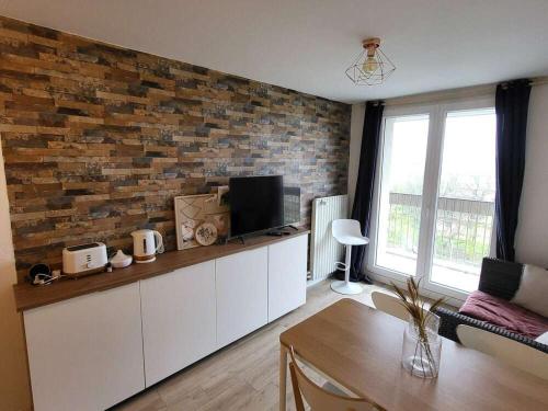 ein Wohnzimmer mit einer Ziegelwand in der Unterkunft Chambre Privée Cosy- Dans Appartement Moderne en Colocation- Tram A -P5-2 in Lormont