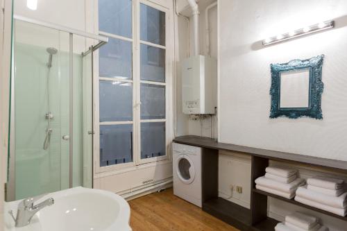 a bathroom with a sink and a washing machine at Opéra Septembre in Paris