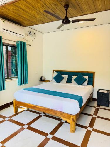 a bedroom with a large bed with blue pillows at Coastal Home in Diveagar