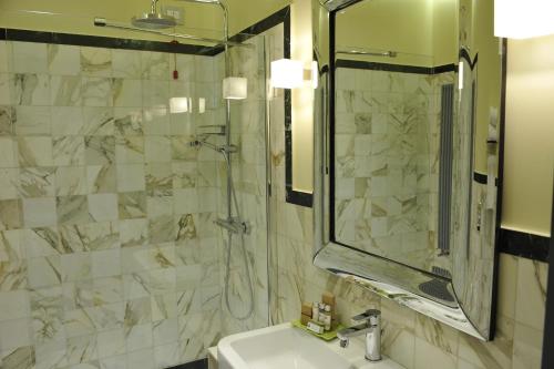 a bathroom with a sink and a shower and a mirror at Palazzo del Senatore in Atina