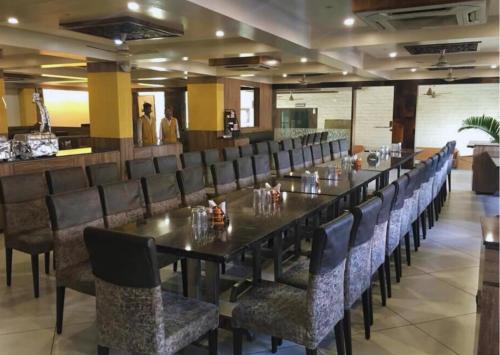 une salle à manger avec une longue table et des chaises dans l'établissement Royale Heritage, à Nashik