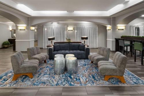 a lobby with a couch and chairs on a rug at La Quinta by Wyndham San Antonio Airport in San Antonio
