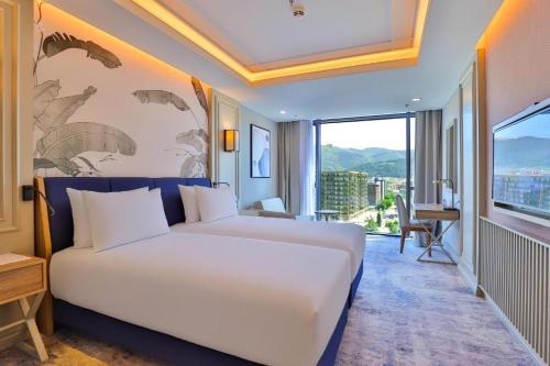 a bedroom with a white bed and a large window at Sia Hotel Thermal & Spa Bursa in Nilüfer