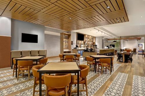 a restaurant with tables and chairs and a kitchen at Hyatt Place Prince George in Prince George