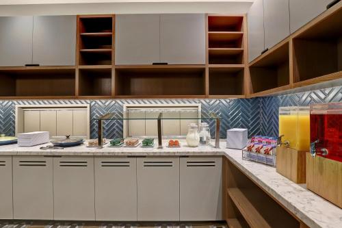 a large kitchen with white cabinets and shelves at Hyatt Place Prince George in Prince George
