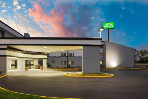 a building with aania sign in a parking lot at Wingate by Wyndham Lincoln Airport East I-80 in Lincoln