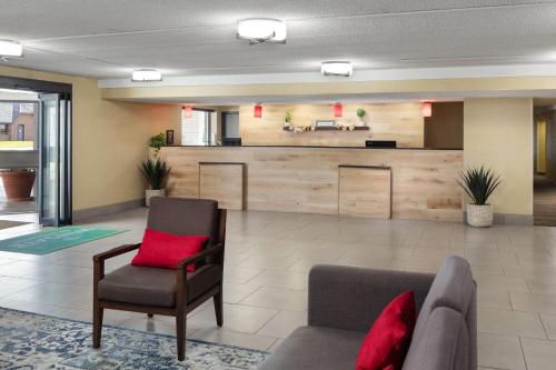 a waiting room with a couch and a chair at Wingate by Wyndham Lincoln Airport East I-80 in Lincoln