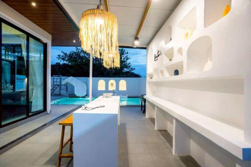 Cette chambre comprend un comptoir blanc et un lustre. dans l'établissement Walters House Pool Villa Pattaya, à Ban Huai Yai