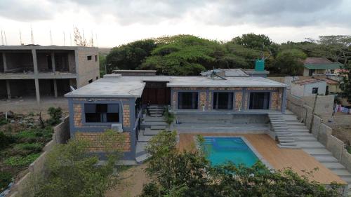 a house with a swimming pool in front of it at lodge3a in Ponta do Ouro