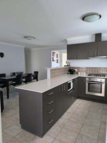 a kitchen with gray cabinets and a table and chairs at 47 Cape View resort in Broadwater