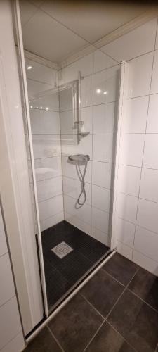 Un baño con ducha con puerta de cristal. en Apartment centrally located in Tromsø with free parking, en Tromsø