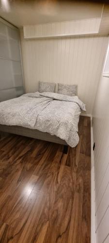 una cama en una habitación con suelo de madera en Apartment centrally located in Tromsø with free parking, en Tromsø