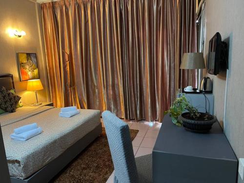 una camera da letto con un letto, un tavolo e una televisione di Pickyard Guest House a Phumĭ Prêk Chrey