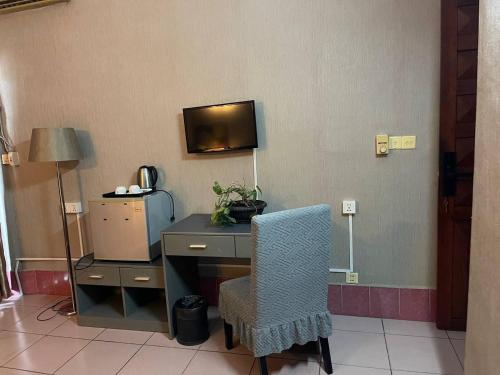 una stanza con una scrivania con una sedia e una tv di Pickyard Guest House a Phumĭ Prêk Chrey