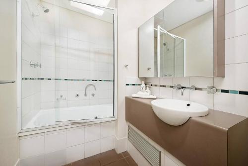Un baño blanco con lavabo y ducha en Sunset on Fearn, lovely 2 bedroom apartment, en Margaret River Town