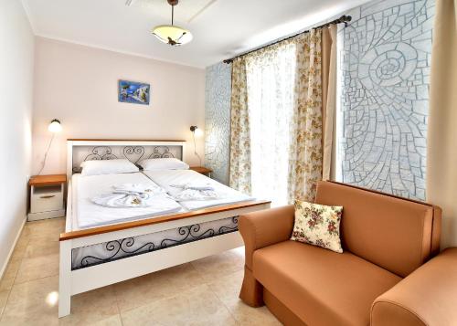 a bedroom with a bed and a chair and a window at Sirena Palace Family Hotel in Obzor