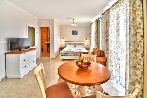 a living room with a table and a bedroom at Sirena Palace Family Hotel in Obzor