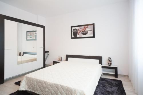 une chambre avec un grand lit blanc et un miroir dans l'établissement Casa Fermecata, à Vişeu de Sus