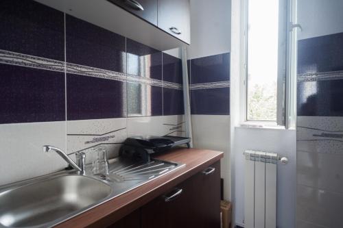 une petite salle de bain avec un lavabo et une fenêtre dans l'établissement Casa Fermecata, à Vişeu de Sus