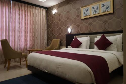 een hotelkamer met een groot bed en 2 stoelen bij Hotel Brahmani in Jajpur Road