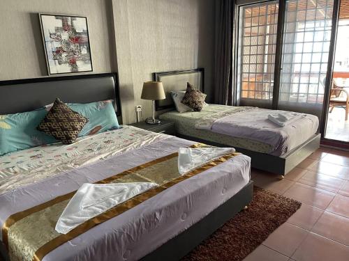 una camera da letto con due letti e una finestra di Pickyard Guest House a Phumĭ Prêk Chrey