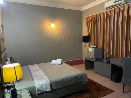 una camera da letto con un letto e una scrivania con una lampada di Pickyard Guest House a Phumĭ Prêk Chrey