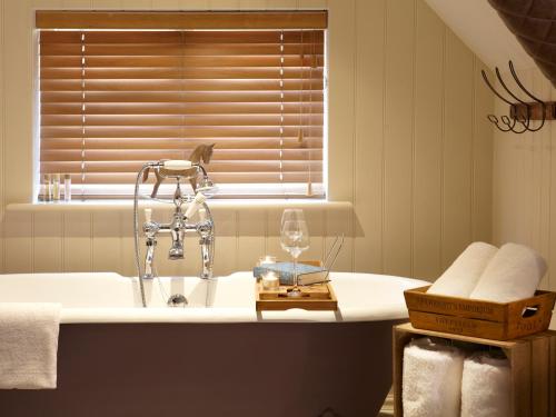 a bathroom with a bath tub with a sink at The Plough Inn & Cottages in Scarborough