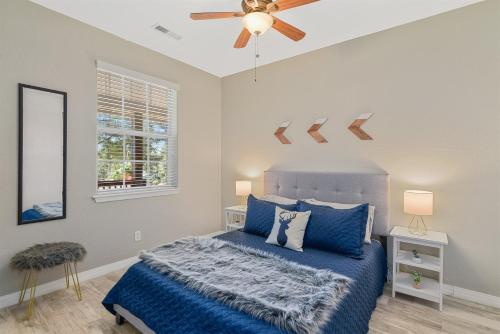 a bedroom with a blue bed and a ceiling fan at Sublime Mountain Retreat Pool Table Fire-Pit Arcade Game Ideal Location w Central AC in Flagstaff