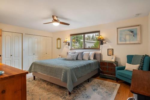 a bedroom with a bed and a blue chair at 3 Bed Gorgeous Views Hot Tub Dog Friendly Ada in Langley