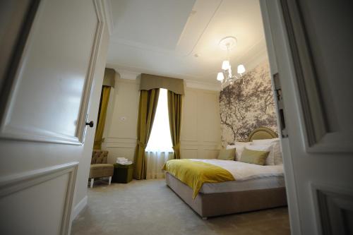 a bedroom with a bed with a yellow blanket at Hotel Splendid 1900 in Craiova
