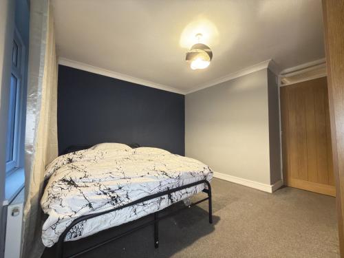 a bedroom with a bed with a blue wall at Bright Double Room in Wellingborough in Harrowden