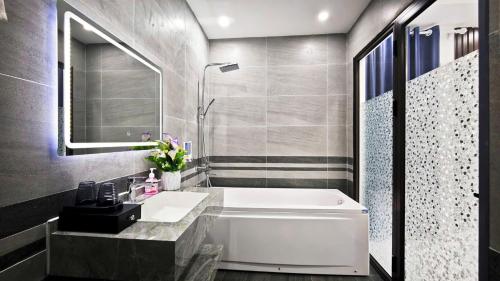 a bathroom with a white tub and a sink at Hana Homestay KGR in Xuan Dam