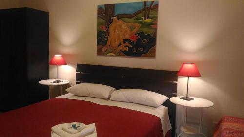 a bedroom with a red bed with two lamps at Domus Taranto unica sede in Taranto