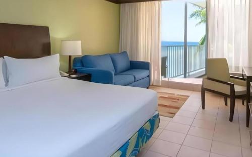 a hotel room with a bed and a blue chair at Catalonia Montego Bay - All Inclusive in Montego Bay