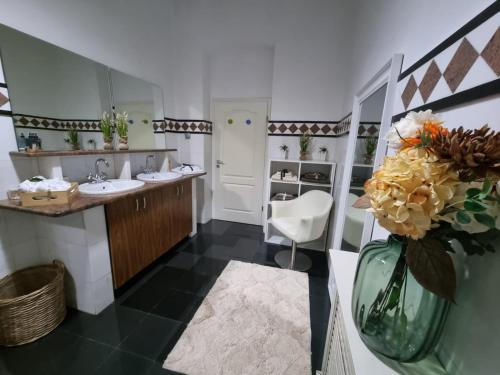 a bathroom with two sinks and a vase of flowers at Central House Craiova in Craiova