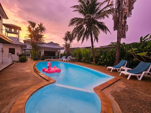 een zwembad met een roze praalwagen in een achtertuin bij Sansuko Ville Panwa in Ban Bo Rae