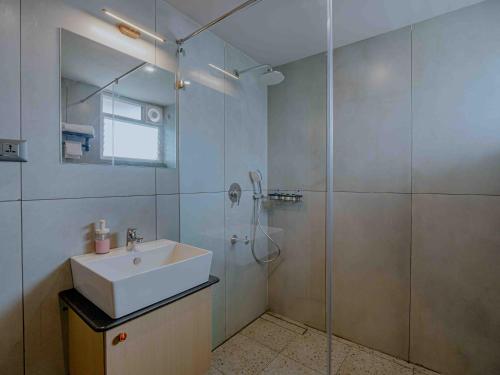 a bathroom with a shower and a sink and a glass shower stall at Nine, Boutique hotel with luxury room stay, mysore in Mysore