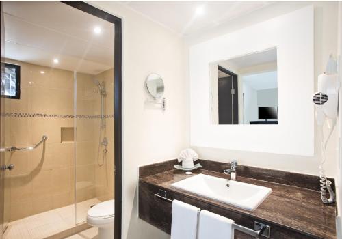 un bagno con lavandino, WC e specchio di Allegro Cozumel All-Inclusive a Cozumel