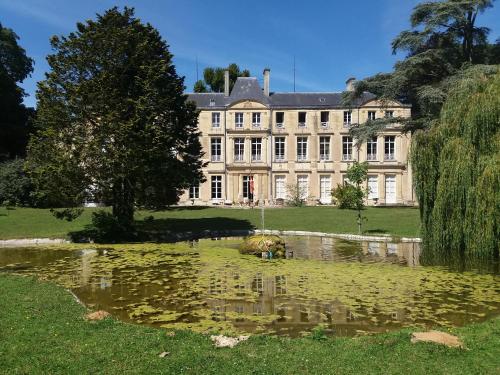 a large house with a pond in front of it at Chateau des Chevaliers de Grand Tonne in Sainte-Croix-Grand-Tonne