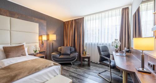 a hotel room with a bed and a desk at PLAZA Premium Darmstadt in Darmstadt
